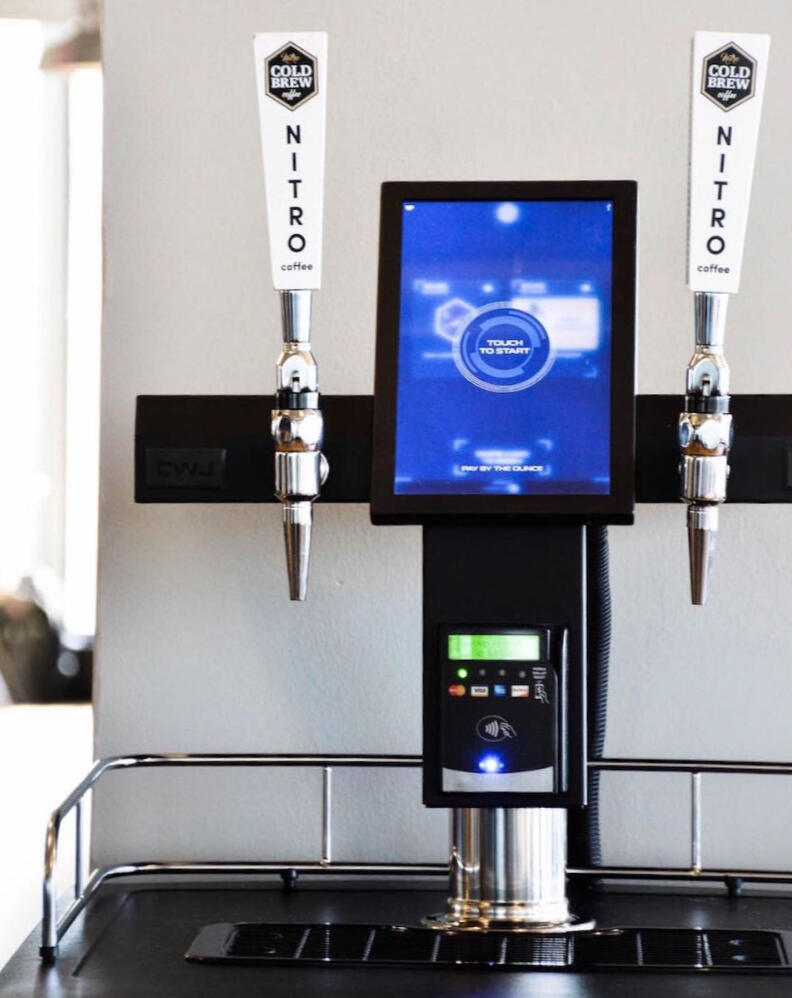 Sleek nitro cold brew coffee kiosk with touchscreen interface and 'Pay By The Ounce' self-serve functionality, ideal for office or commercial settings in Austin, Texas.